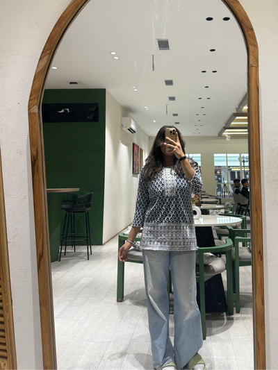 Person taking a mirror selfie in a modern interior setting